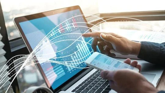 Person, die einen Laptop und ein Smartphone verwendet