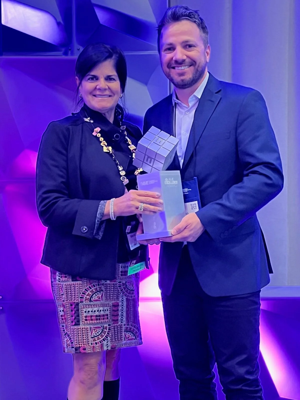 two people holding an award between them