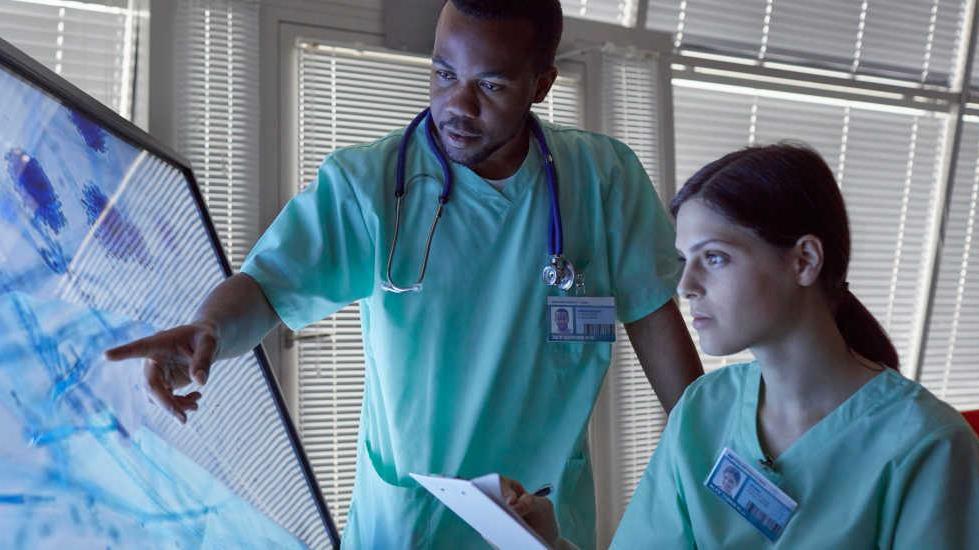 two healthcare professionals using large touchscreen