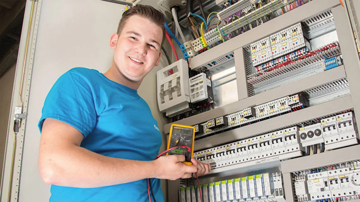 Aprendiz masculino calibrando una máquina