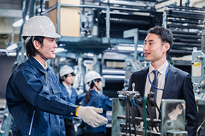 Zwei Männer unterhalten sich in einer Produktionshalle