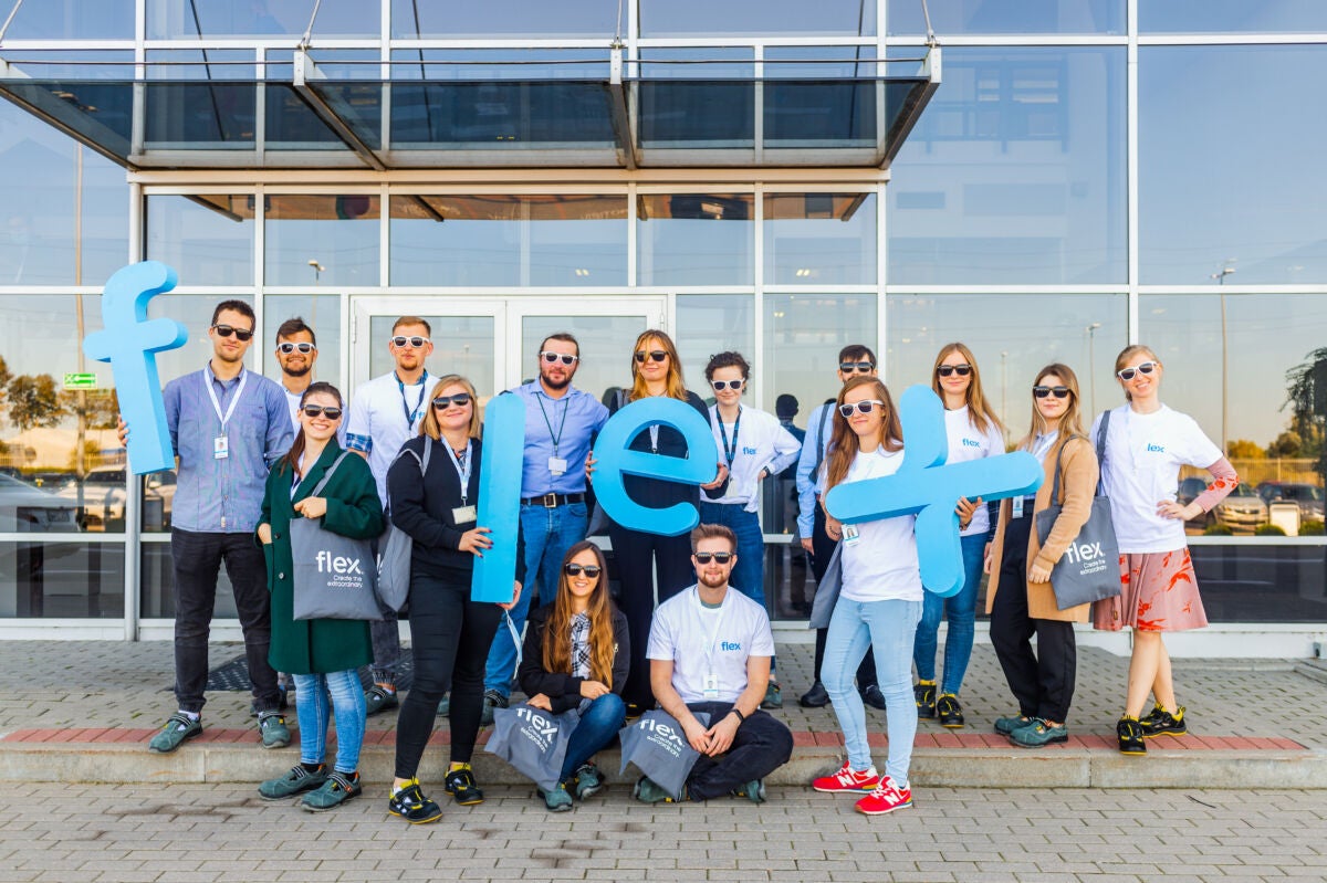 Junges Team aus Praktikanten und Auszubildenden mit Flex-Logo