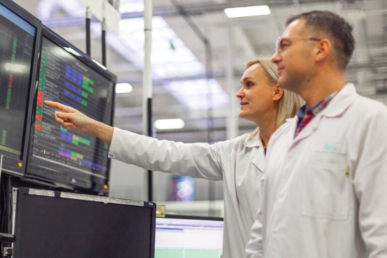 Flex employees using a monitor for reverse logistics and value-added fulfillment services