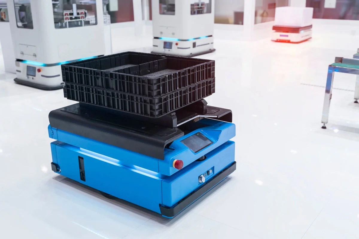 El coche robot de almacén lleva el montaje de cajas de cartón en la fábrica.